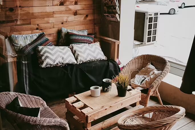A velvet pillow next to a window with a candle and books
